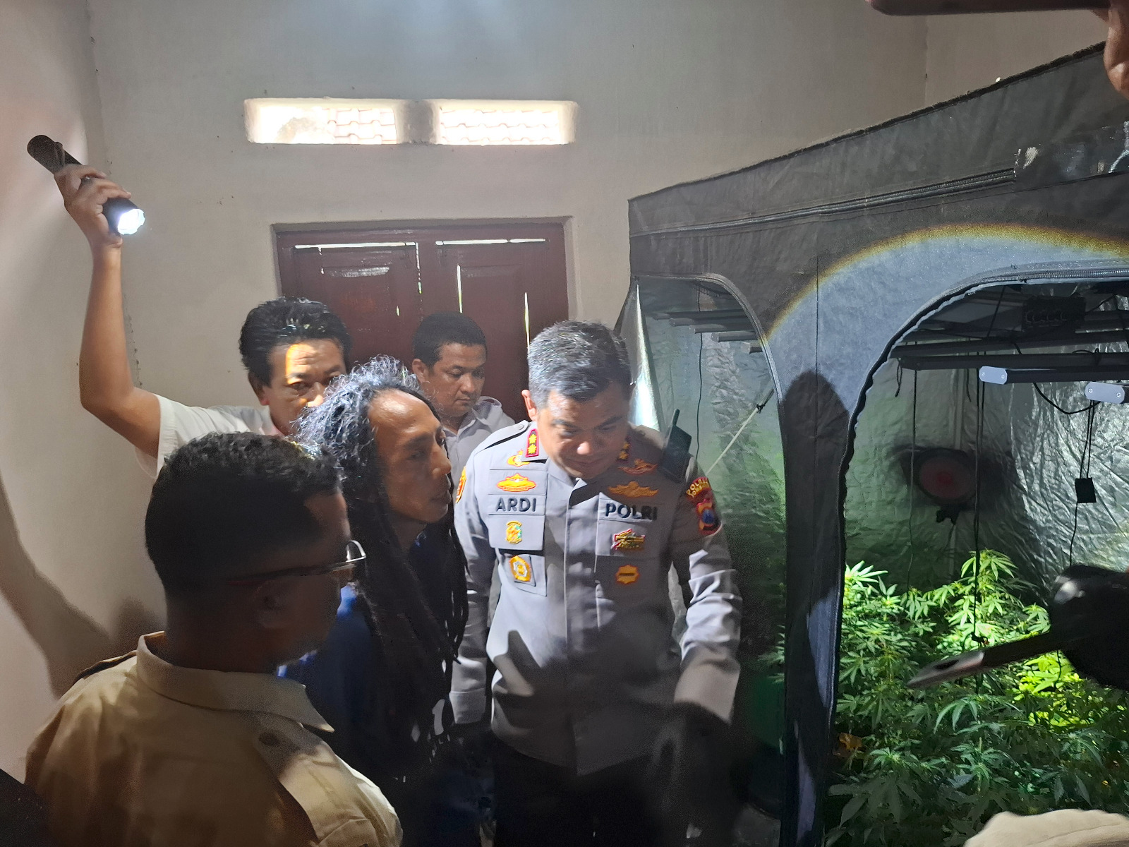 Polisi saat menggerebek greenhouse ganja di rumah kontrakan di Jombang