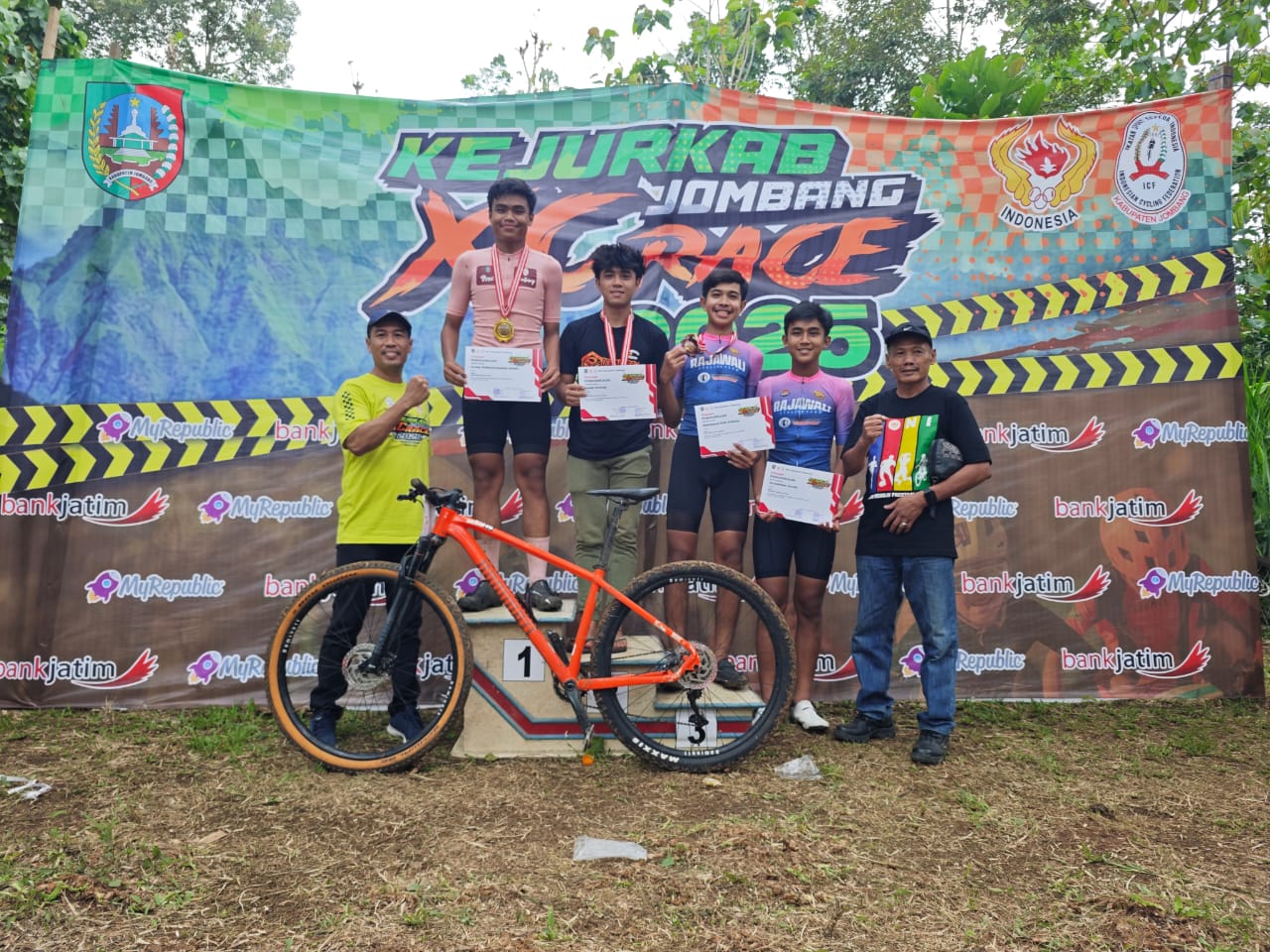 BERPRESTASI: Ketua Umum KONI Jombang, Sumarsono (kanan) menyerahkan piagam kepada juara Kejurkab XCRace di Kandang Kambing Bike Park, Pangklungan, Wonosalam, Minggu (14/12).  &nbsp;