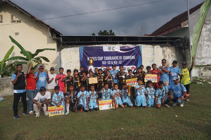 EVENT PERDANA: Kepala Desa Tambakrejo Mohammad Nasir Fadlillah bersama tim juara Kades Cup Tambakrejo Jombang kelompok usia 12 tahun didampingi panitia beserta