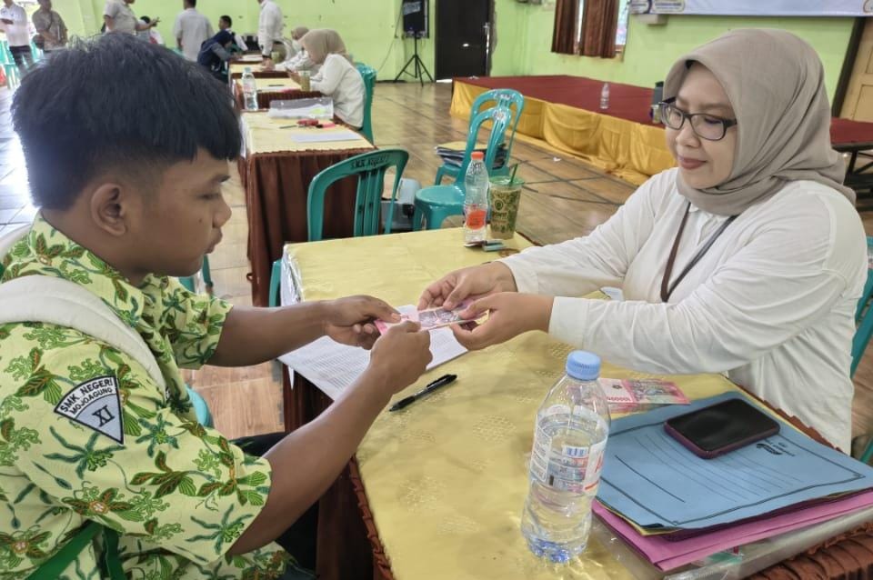 Siswa menerima bantuan biaya pendidikan di SMKN 3 Jombang, Rabu (24/12).