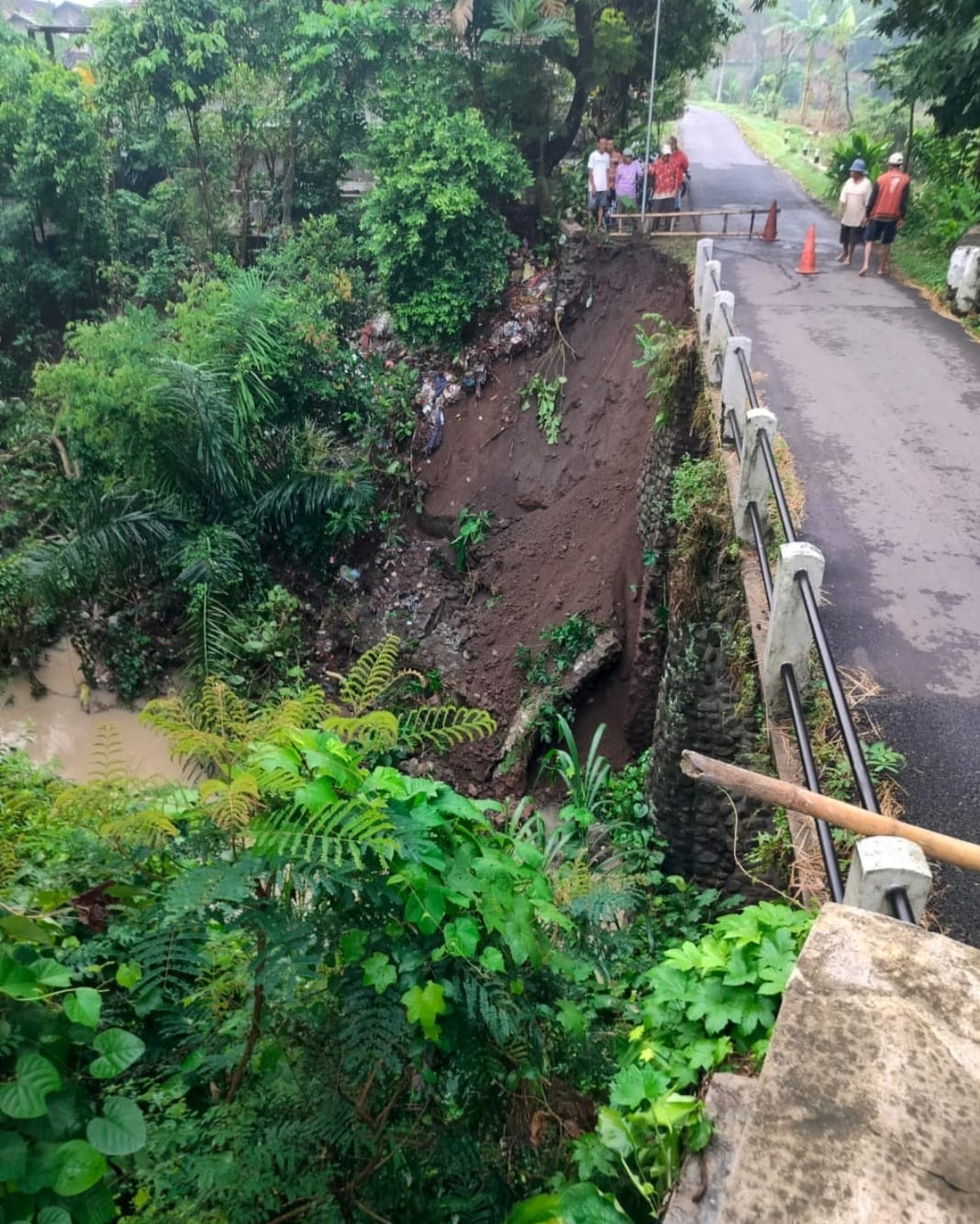 BAHAYA: Kondisi sayap jembatan di Desa Latsari, Kecamatan Mojowarno, ambrol setelah terkikis aliran air deras.