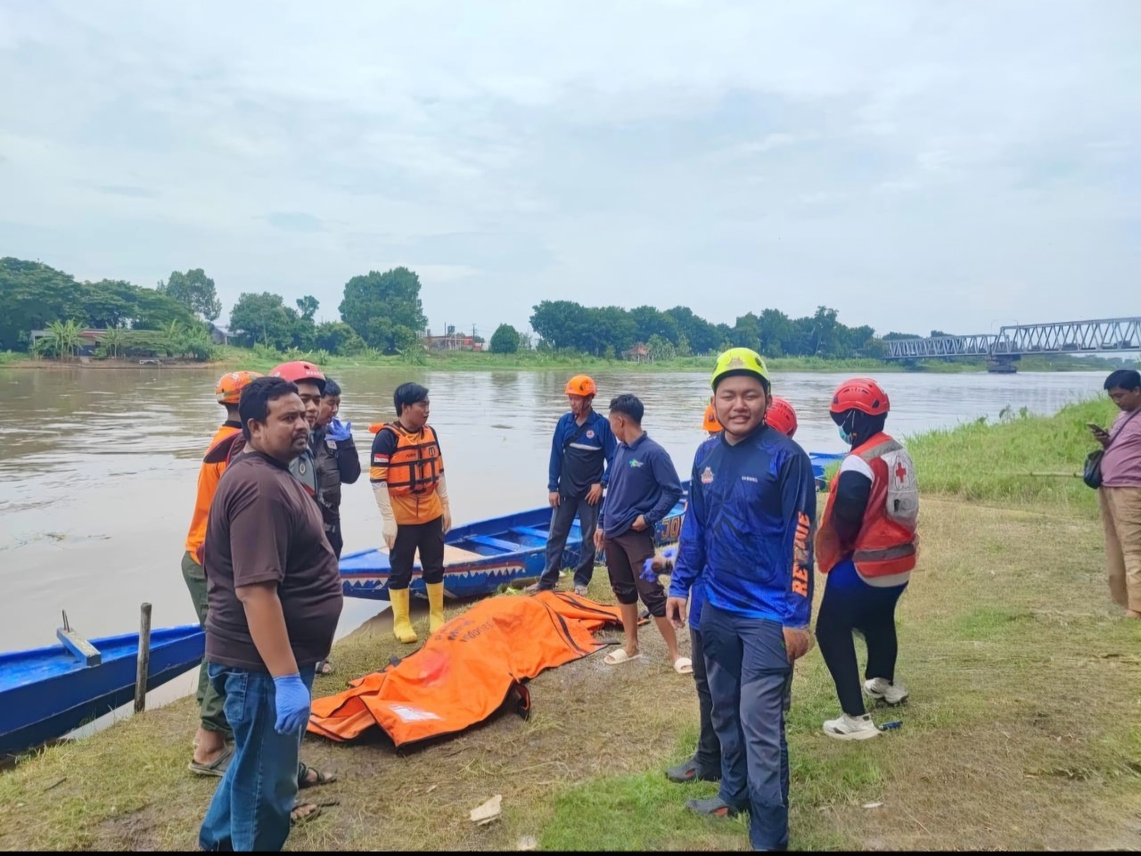 Petugas dan relawan saat mengevakuasi jasad korban dari dalam sungai brantas