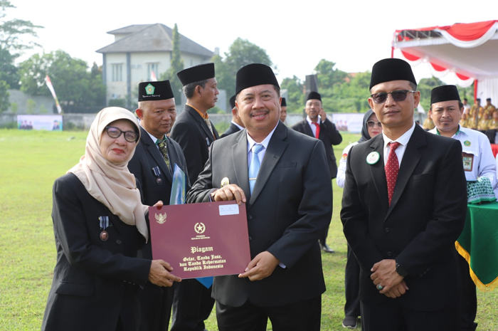 SELAMAT: Bupati Warsubi didampingi Kepala Kantor Kemenag Jombang Muhajir menyerahkan piagam penghargaan.