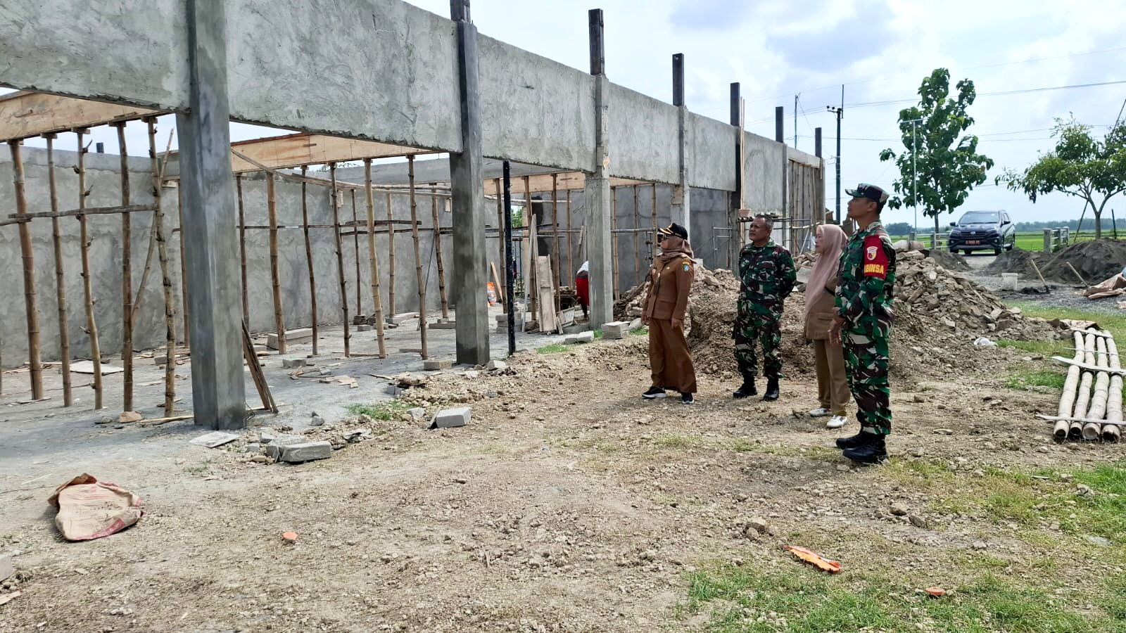 SINERGI LINTAS SEKTORAL: Kepala Desa Ngogri Lis Hartatik bersama jajaran Forkopimcam Megaluh saat meninjau progres pembangunan gedung KDMP Desa Ngogri.