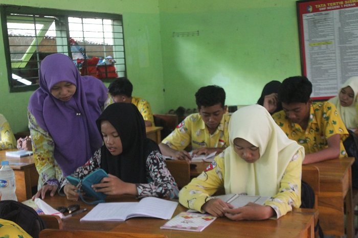 SEMANGAT: Pembimbing pendidikan diniyah yang belum diangkat menjadi PPPK paruh waktu saat mengajar di SMPN 1 Perak, (13/11).  &nbsp;