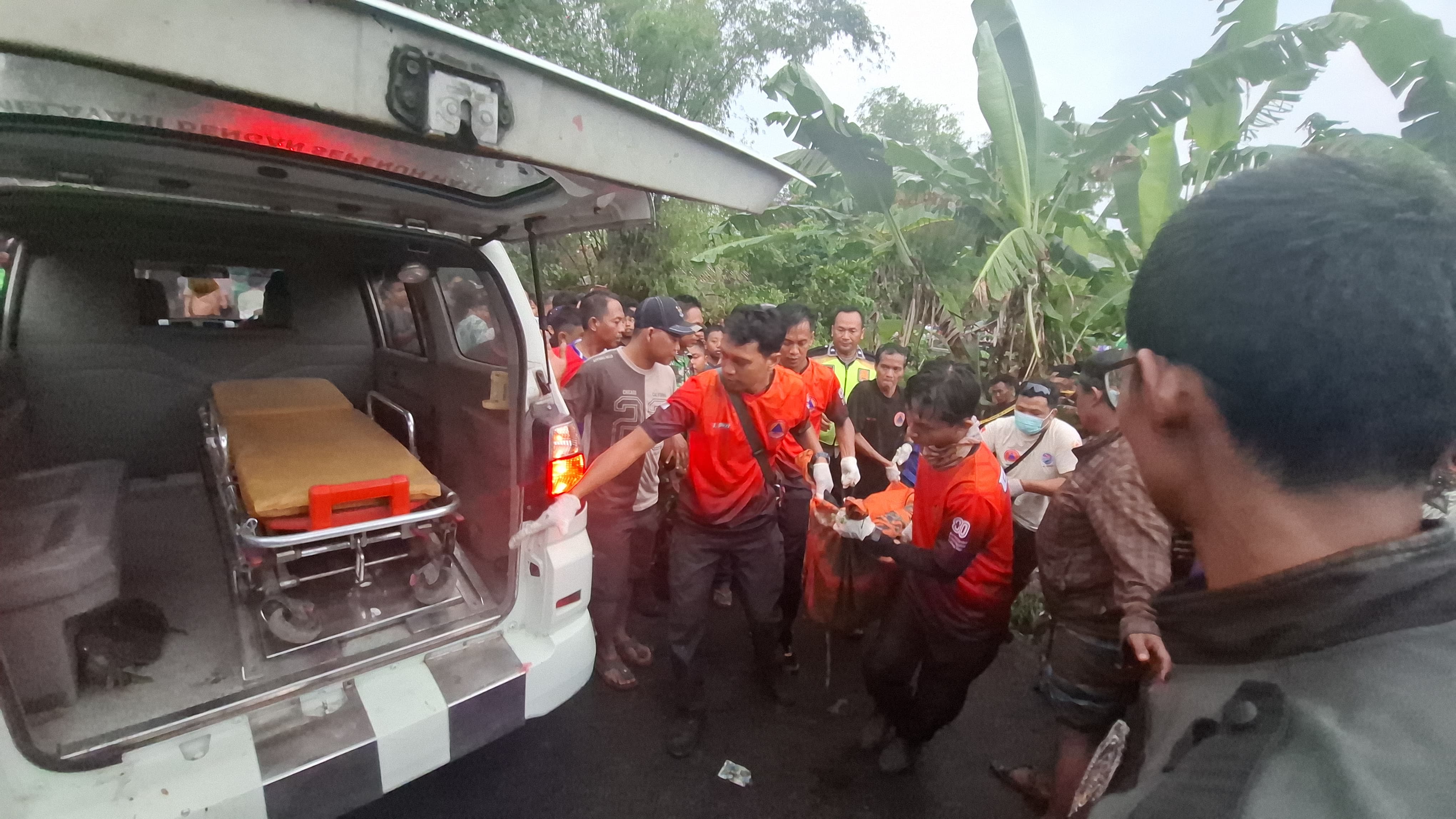 Petugas saat mengevakuasi jasad korban dari dalam sungai