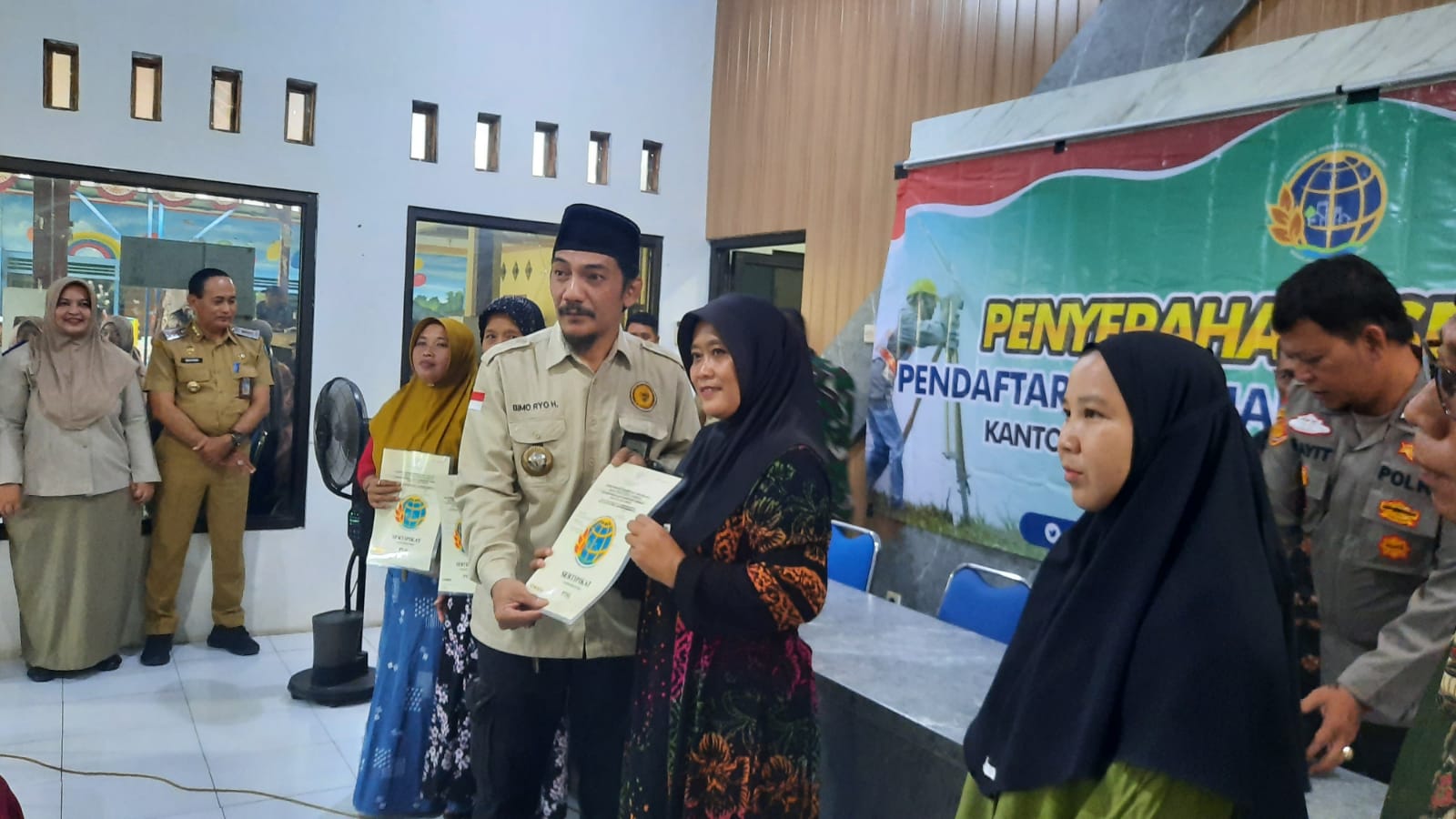 UNTUK WARGA: Kepala Desa Plosogeneng Bimo Ryo Herdiawan menyerahkan sertifikat kepada warga desa di kantor desa setempat, Selasa (27/1) siang.