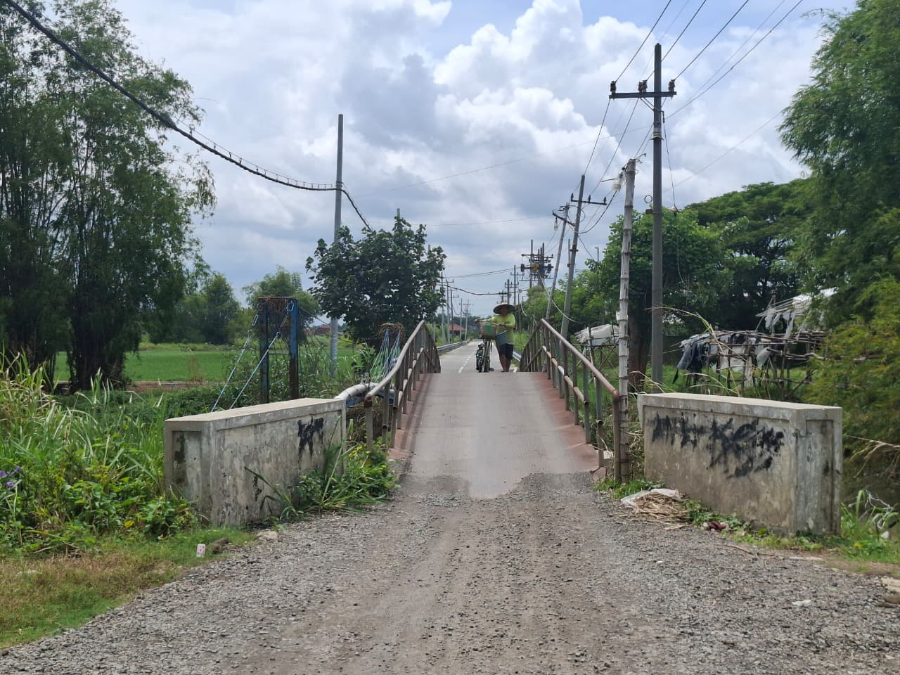 MENYEMPIT: Pengendara melintas jembatan di Desa Jatigedong, Kecamatan Ploso, (29/1).  &nbsp;