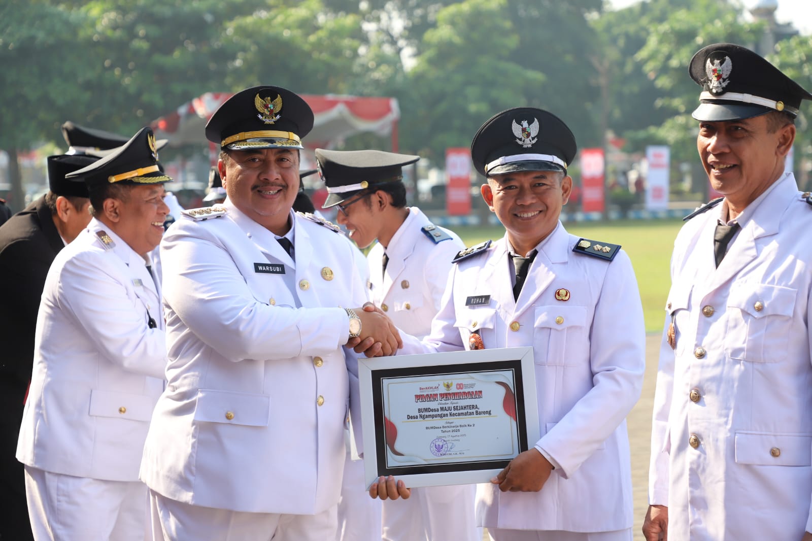  APRESIASI: Kepala Desa Ngampungan Rohan saat menerima piagam penghargaan dari Bupati Jombang Warsubi sebagai salah satu BUMDesa berkinerja baik 2025.