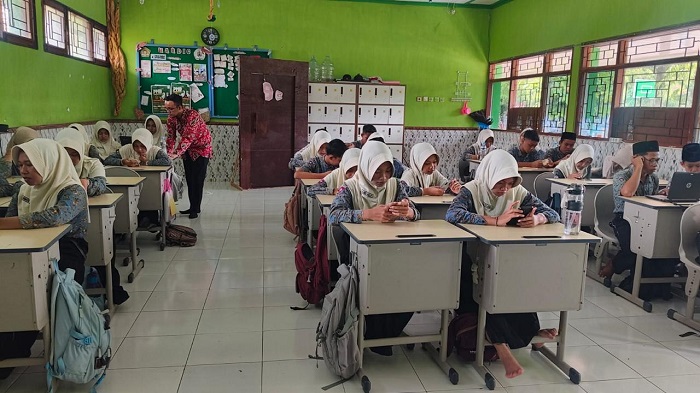 CANGGIH: Pelaksanaan tryout TKA di MTsN 5 Jombang, siswa menggunakan smartphone dan laptop madrasah, kemarin.  &nbsp;
