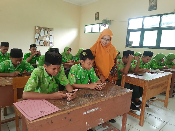 DISIPLIN: Guru MTsN 15 Jombang, Kustiya, saat mengawasi tryout TKA.  &nbsp;