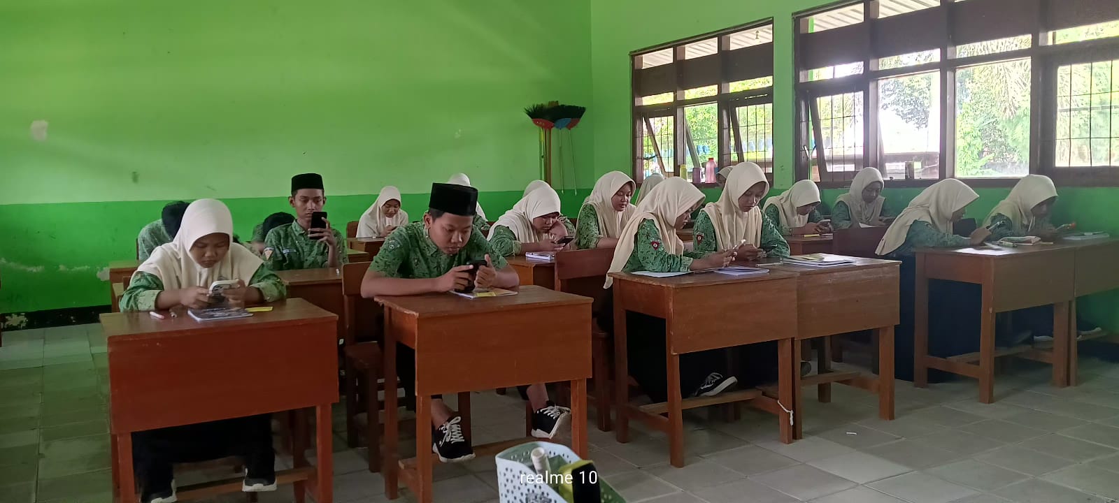 TEKUN: Siswa mengenakan smartphone untuk mengerjakan soal Tryout TKA, Kamis (5/2).  &nbsp;  &nbsp;