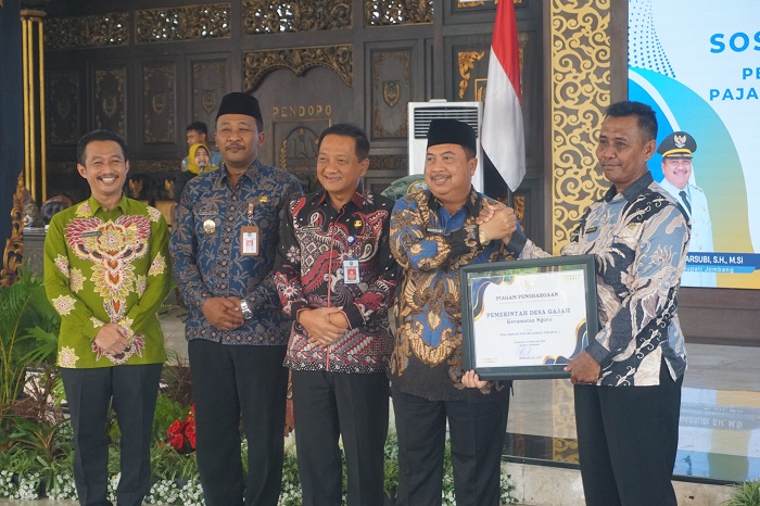APRESIASI KINERJA DESA: Kepala Desa Gajah Suwandi saat menerima piagam penghargaan dari Bupati Jombang Warsubi di Pendopo Kabupaten Jombang, Kamis (5/2) siang.