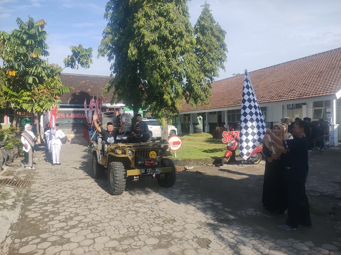 SEMARAK: Kepala SMPN 4 Jombang, Slamet Agus Tri Prastyo SPd, memimpin rombongan gerebek apem mengelilingi wilayah sekitar sekolah, Kamis (12/2) pagi.