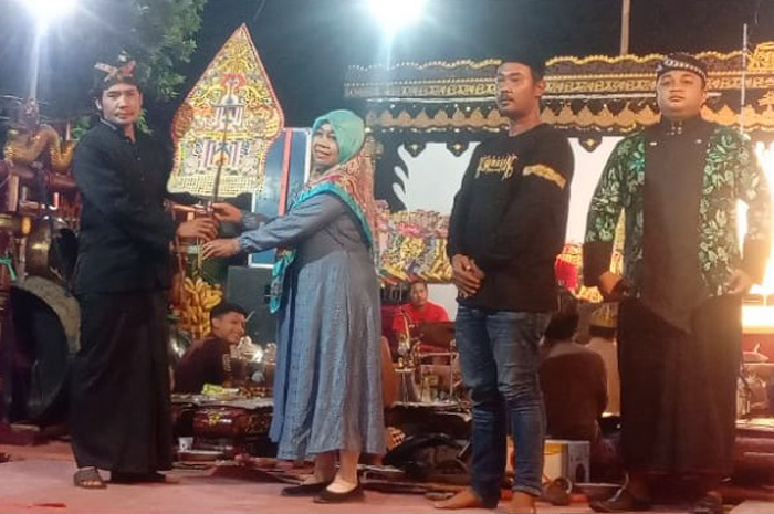 URI-URI BUDAYA: Kepala Desa Kedungmlati Mariyati didampingi Kepala Dusun Krandegan Fendi Setiawan saat menerima gunungan wayang secara simbolis sebagai tanda dibuka