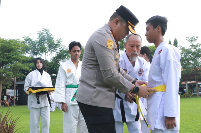 Kapolres sekaligus Ketua Umum Inkanas Jombang, AKBP Ardi Kurniawan, didampingi Wakil Ketua Harian Inkanas, Muchtar, memakaikan sabuk baru kepada perwakilan karateka pada pelantikan sabuk