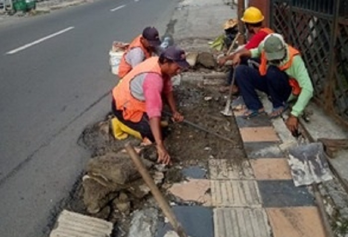 ANTI BANJIR: Petugas dari Dinas Perumahan dan Permukiman Jombang melakukan pemeliharaan drainase untuk mencegah genangan