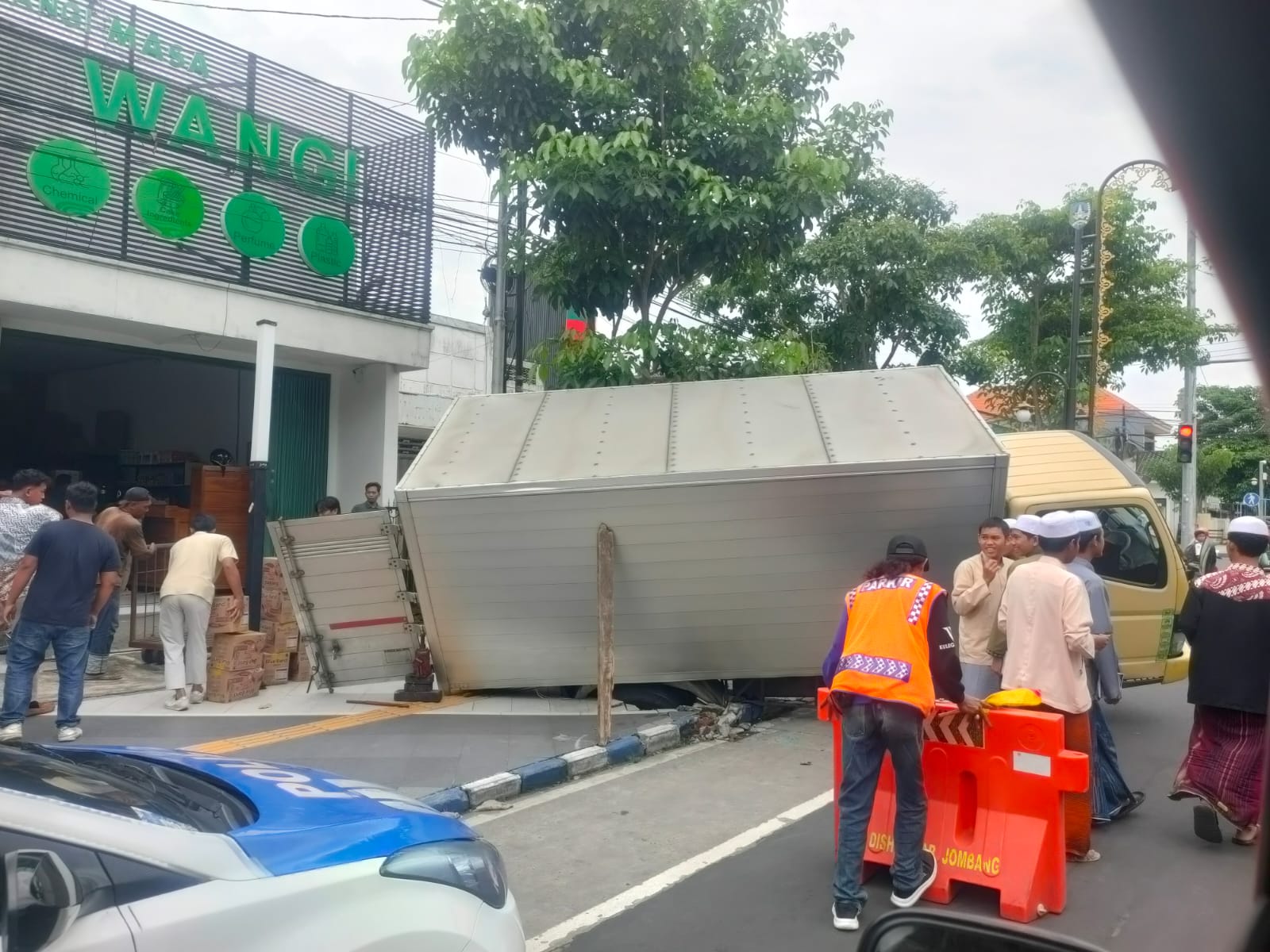 Sebuah truk boks ambles saat nekat naik di jalur pejalan kaki. Insiden itu membuat man hole jebol serta memicu kerusakan fasilitas di sekitarnya.
