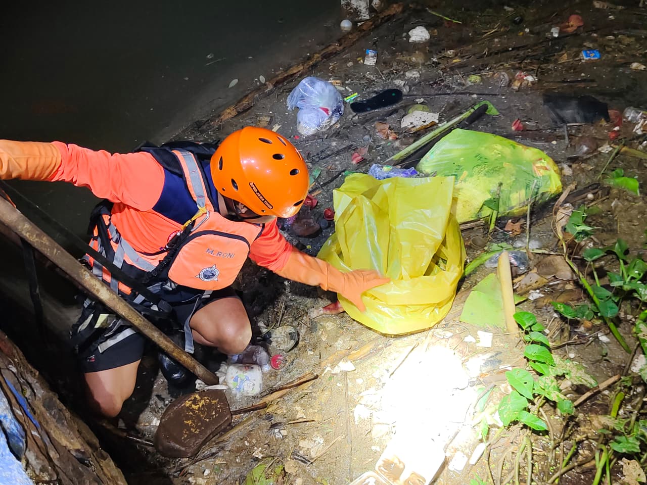 Petugas BPBD Jombang saat mengevakuasi jasad bayi yang ditemukan di Dam Yani SUmobito Jombang