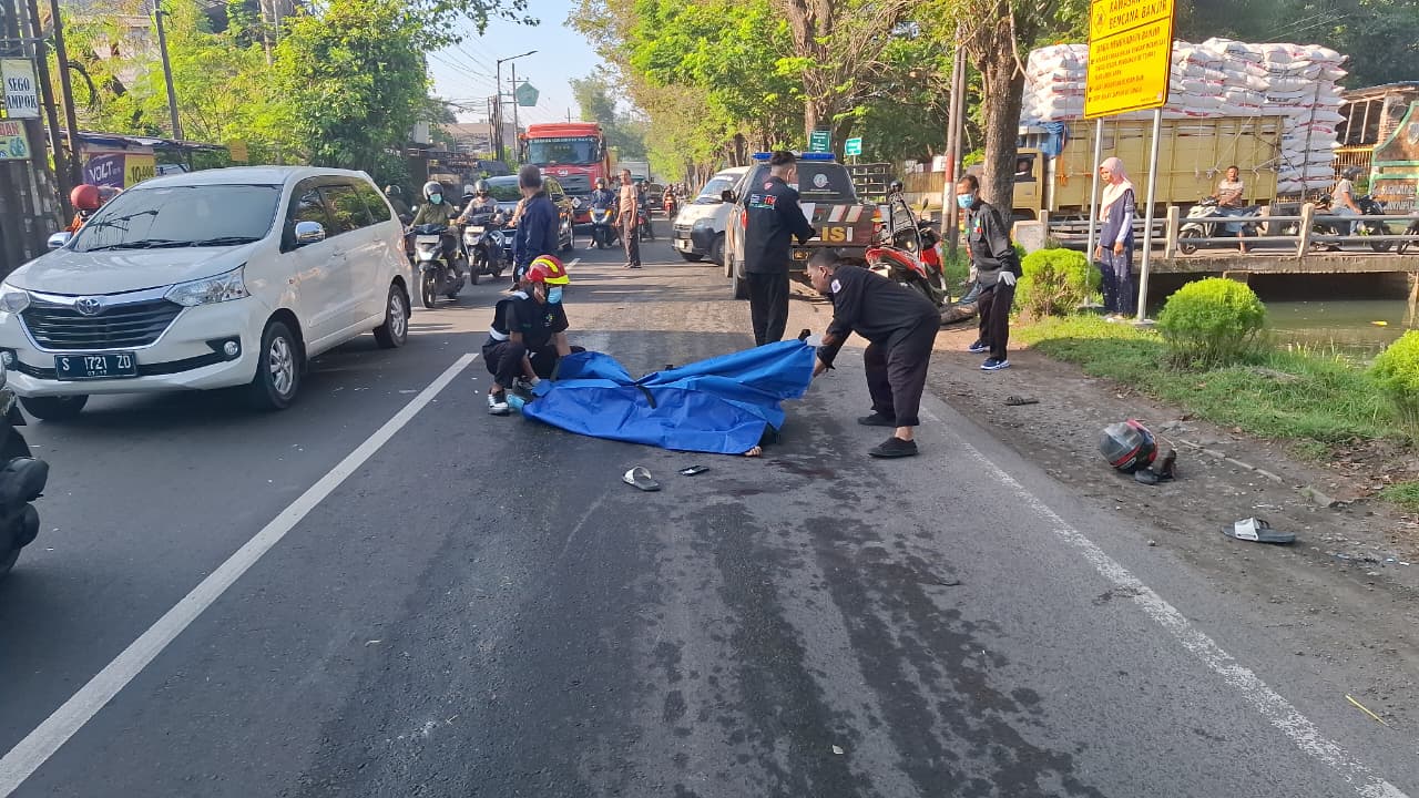 Petugas saat mengevakuasi jasad korban kecelakaan yang meninggal dunia dari lokasi kejadian