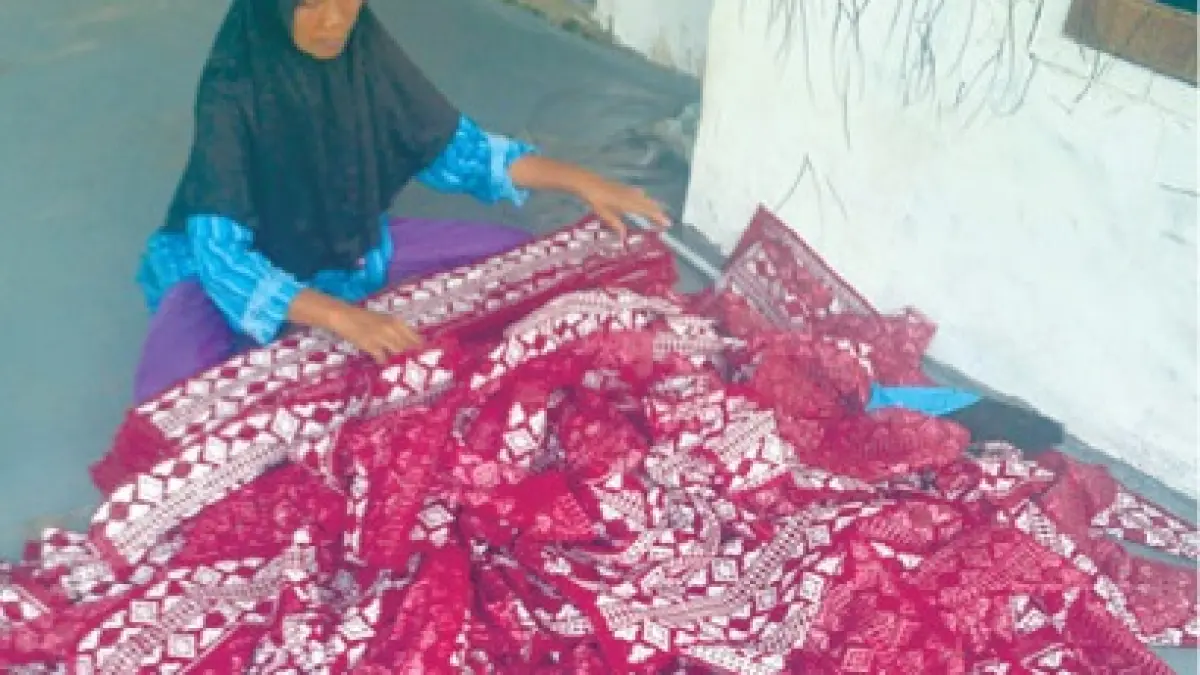 SIAP JAHIT: Warga mengeringkan tas hajatan atau tas parcel Lebaran baru saja disablon di Desa Budugsidorejo, Kecamatan Sumobito.