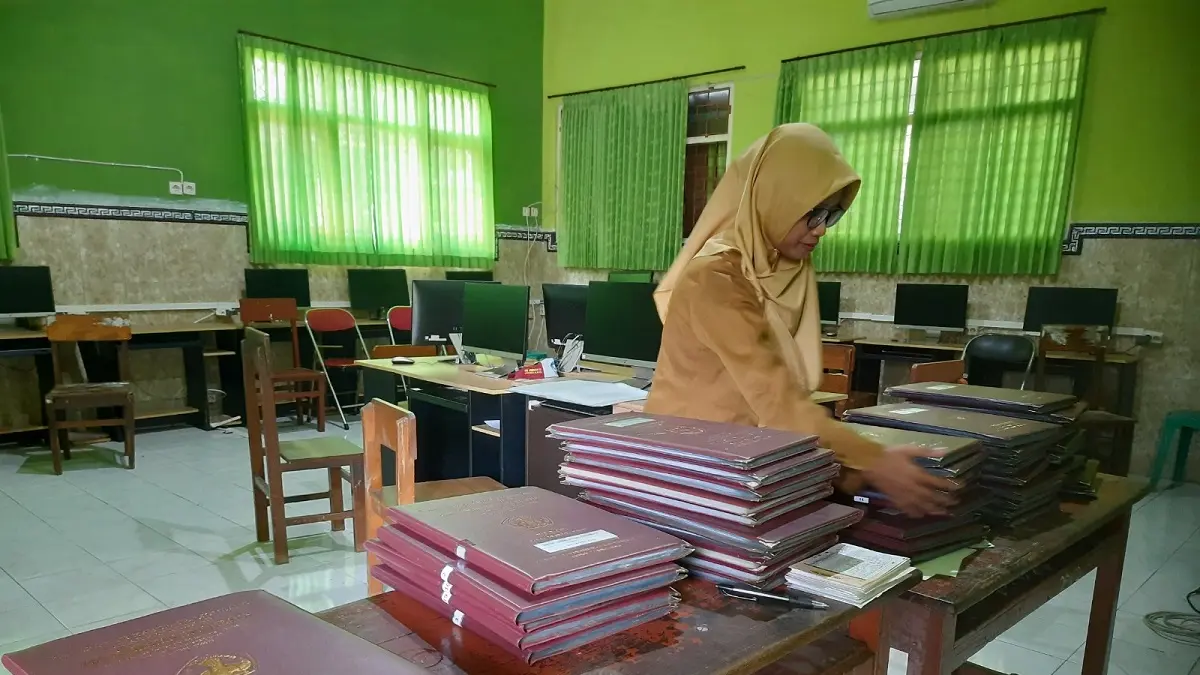 TELATEN: Guru SDN Jombatan 3 Kecamatan Jombang menata rapor siswa untuk persiapan SPMB SMP, kemarin.