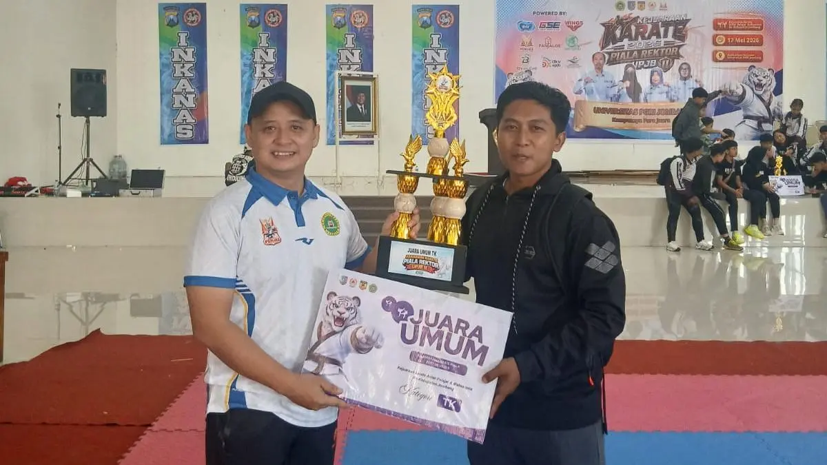 SELAMAT: Aditya Harja Nenggar penanggung jawab kegiatan menyerahkan piala juara umum kategori TK, yang diterima Ganang, pelatih karate TK Permata Hati Jombang