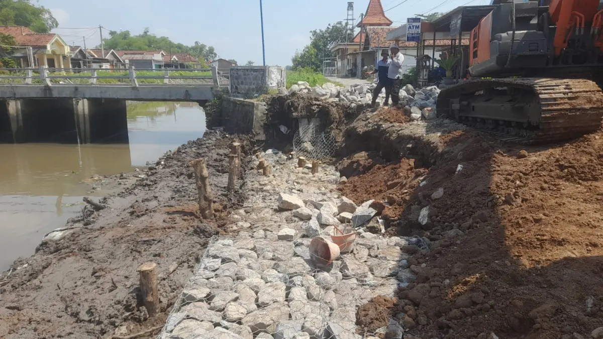 DITANGANI: Tanggul saluran buang Ndero di Dusun Kedungmacan, Desa Kedungbetik, Kecamatan Kesamben yang longsor dipasang bronjong, (18/5).