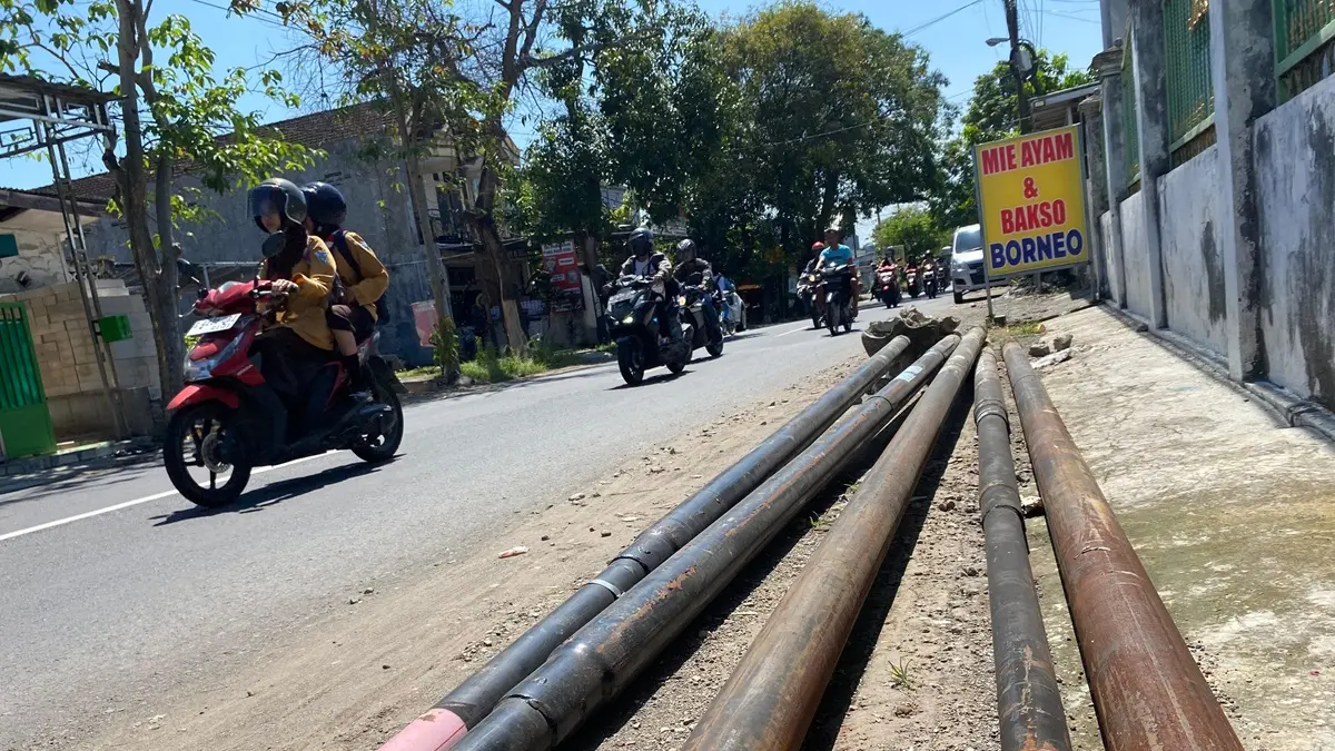 TERGELETAK: Puluhan tiang fiber optik (FO) dibiarkan tergeletak di Jl Kapten Pierre Tendean, Jombang, (29/5).

