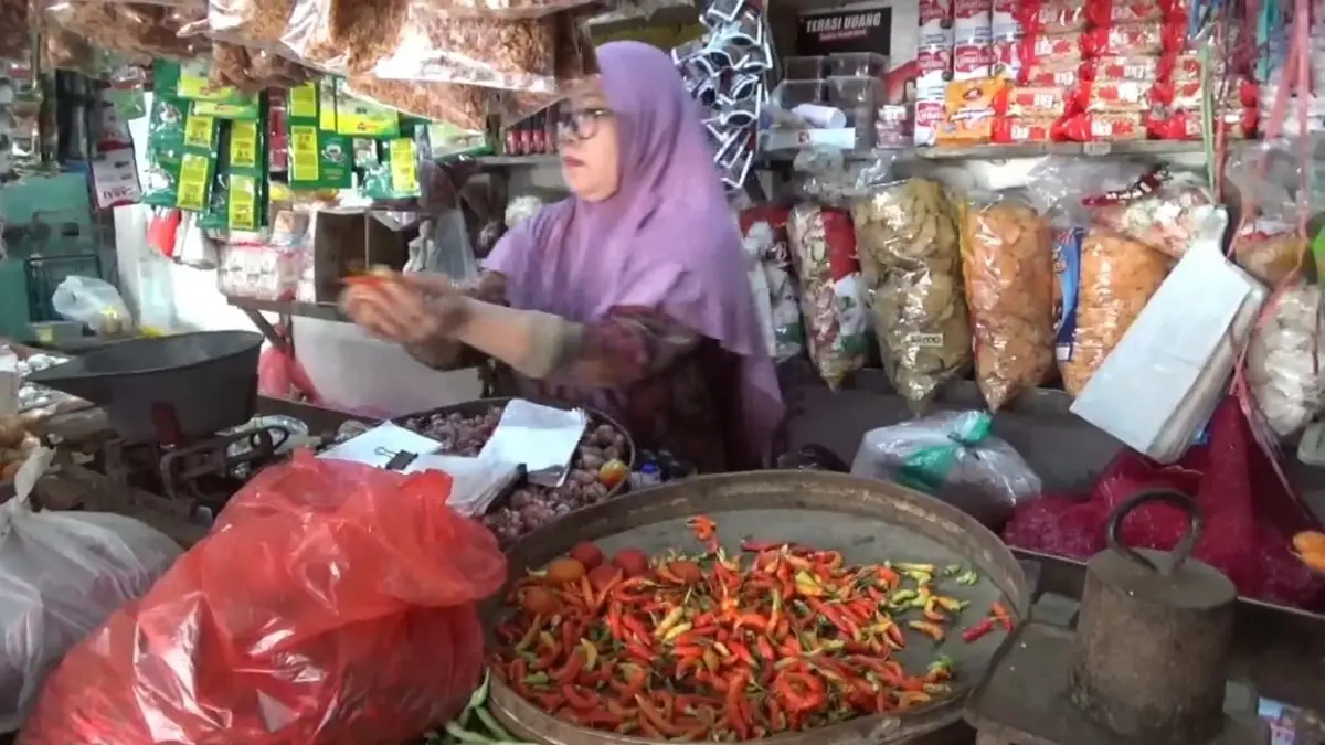 Min Ilmi, pedagang cabai Pasar Pon Jombang saat melayani pembeli.