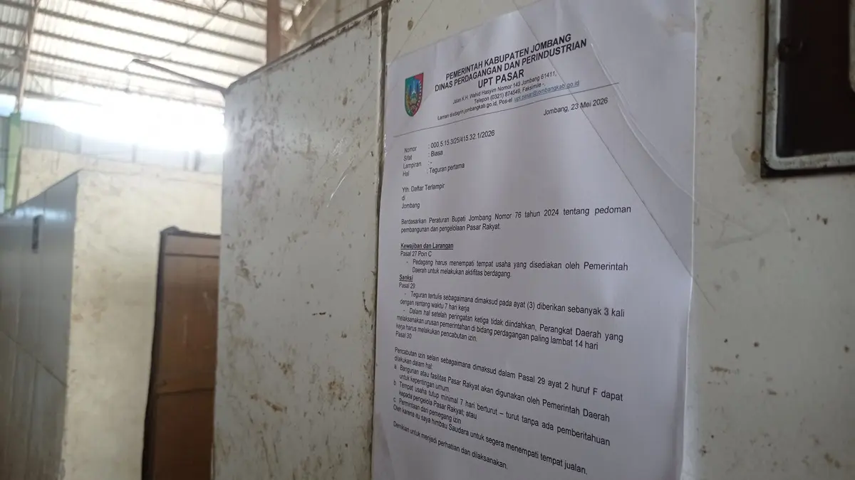 
PERINGATAN: Surat teguran pertama ditempel di lapak atau los berbentuk meja di Pasar Pon, Jombang.
