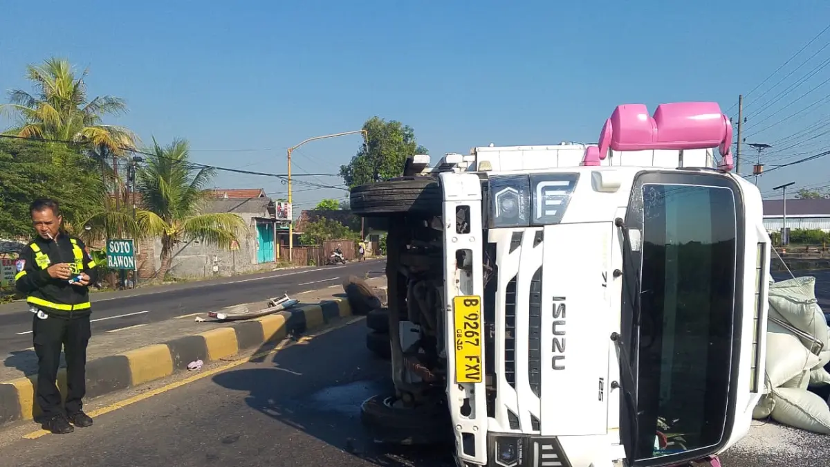 Sebuah truk Isuzu terguling setelah menabrak median jalan di jalur arteri nasional Desa Gambiran, Kecamatan Mojoagung, tepatnya di simpang tiga Ring Road Mojoagung, Senin (8/6) dini hari.