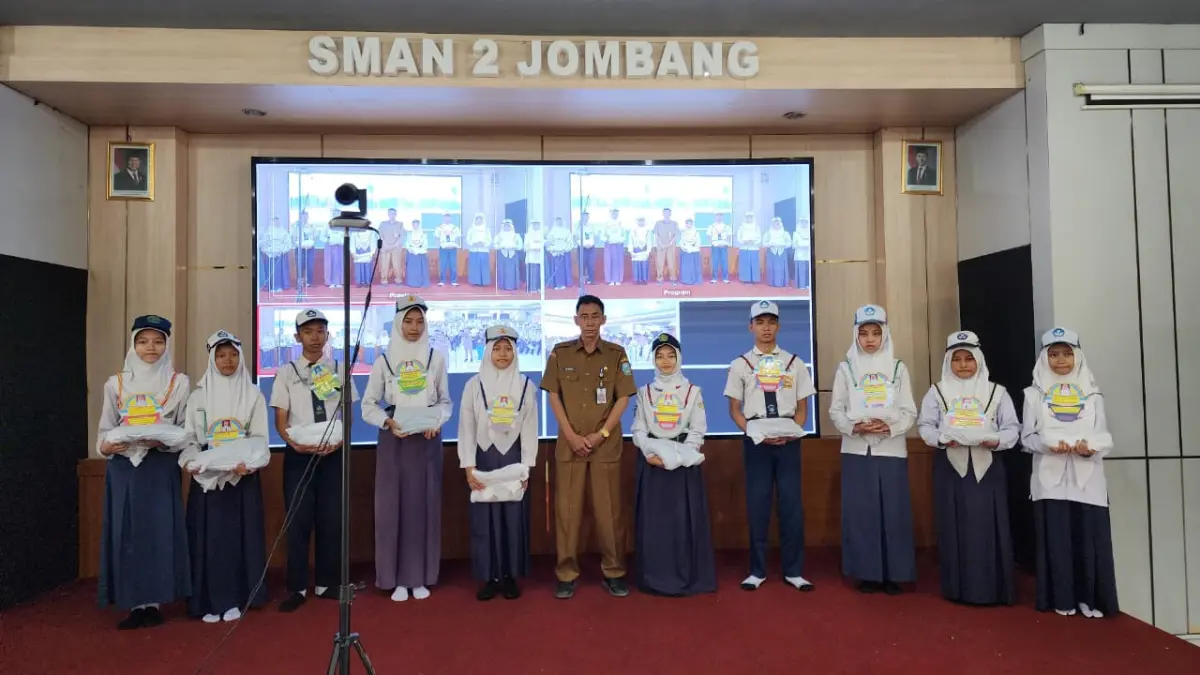 PEDULI: Kepala SMAN 2 Jombang, Budiono MMPd memberikan seragam kepada siswa kurang mampu, Senin (13/7).