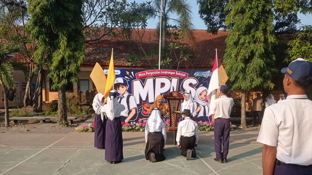 ANTUSIAS: Kepala SMPN 1 Tembelang, Tatit Mustikarini SPd, menyematkan id card kepada perwakilan murid baru saat upacara pembukaan MPLS di SMPN 1 Tembelang, Senin (13/7) pagi.