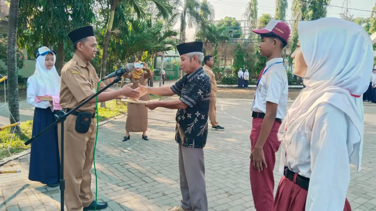 KREATIF: Kepala SMPN 1 Megaluh, Drs Ahmad Su’ud, menyambut perwakilan orang tua dan murid baru saat pembukaan MPLS, Senin (13/7) pagi. 