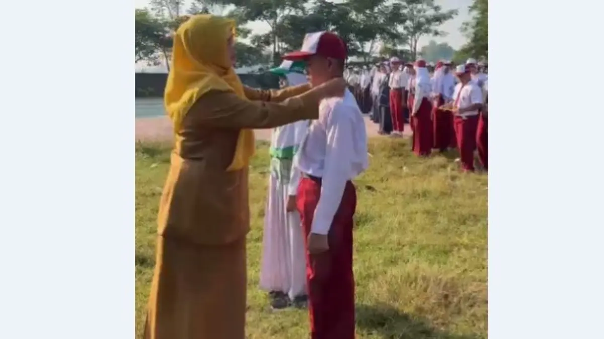 SIMBOLIS: Kepala SMPN 1 Kudu, Srimudayani Dewi Astutik MPd, mengalungkan identitas kepada perwakilan peserta MPLS di SMPN 1 Kudu, Senin (13/7) pagi.