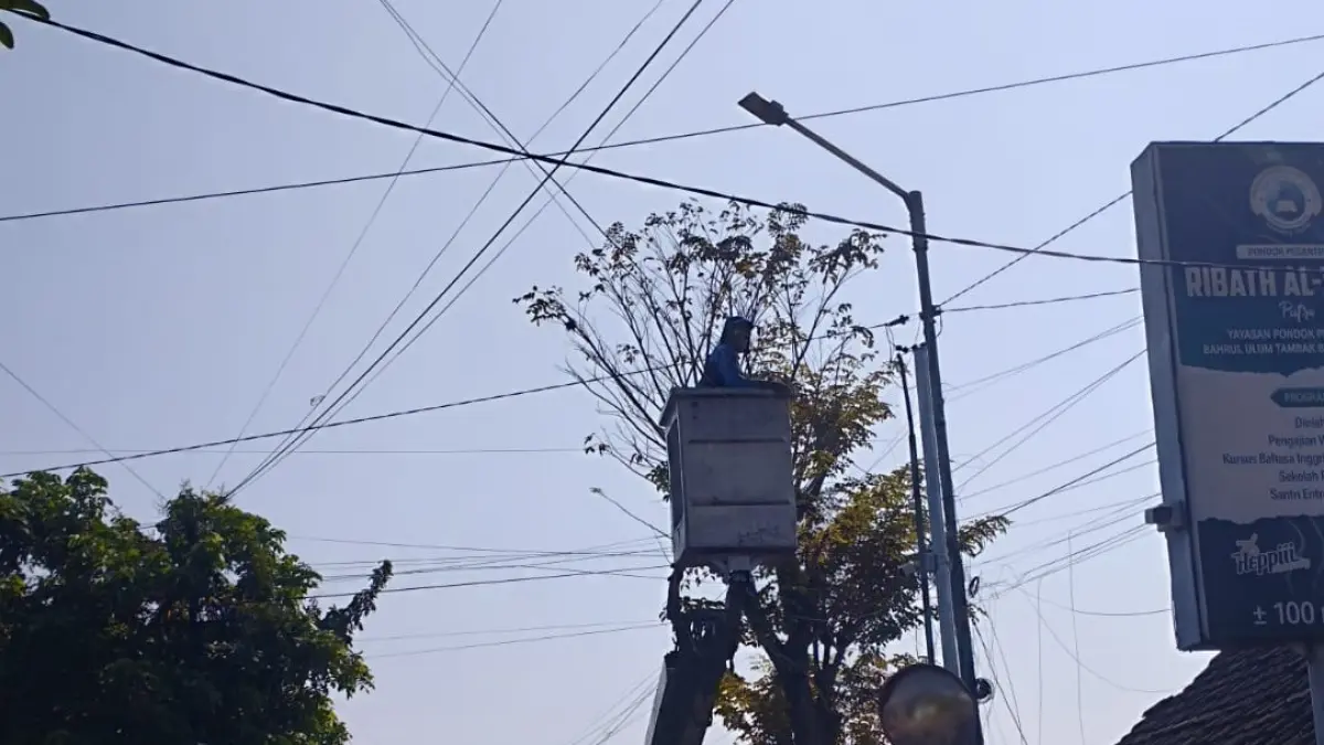 Petugas mengganti lampu PJU di area Ponpes Bahrul Ulum, Tambakberas sebagai persiapan Muktamar ke-35 NU.