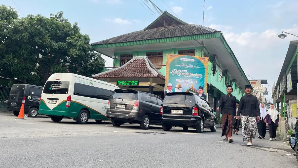 PONDOK INDUK: Para santri melintas di depan gedung Yayasan PPBU Tambakberas, Jombang. Bangunan tersebut sedianya disiapkan sebagai lokasi Media Center Muktamar ke-35 NU, 27-31 Agustus mendatang.