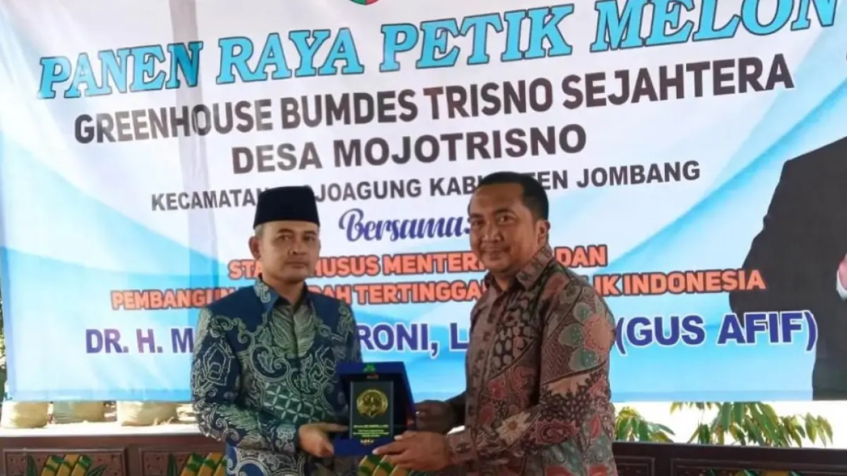 APRESIASI: Staf Khusus Menteri Desa dan PDT RI, Dr HM Afif Zamroni Lc MEI (Gus Afif) memberikan cenderamata kepada Kepala Desa Mojotrisno, Nanang Sugiarto saat kunjungan panen raya petik melon di Greenhouse BUMDes Trisno Sejahtera, Sabtu (25/7).

&nbsp;