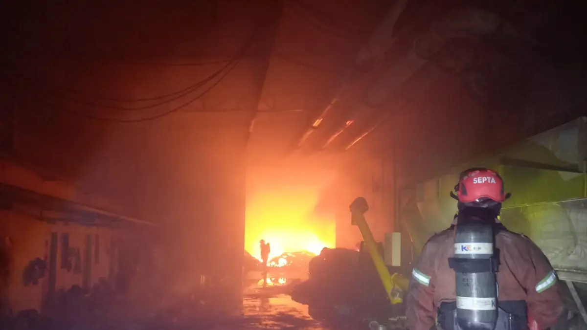 Petugas berusaha memadamkan kebakaran di pabrik pakan ternak di Dusun Guwo, Desa Latsari, Kecamatan Mojowarno, Jumat (24/7) malam.