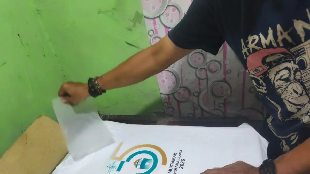 MANDIRI: Karyawan sablon kaus berdesain muktamar asal Kota Mojokerto mengerjakan stok yang akan dijual pada pelaksanaan Muktamar NU di PPBU Tambakberas, Jombang.