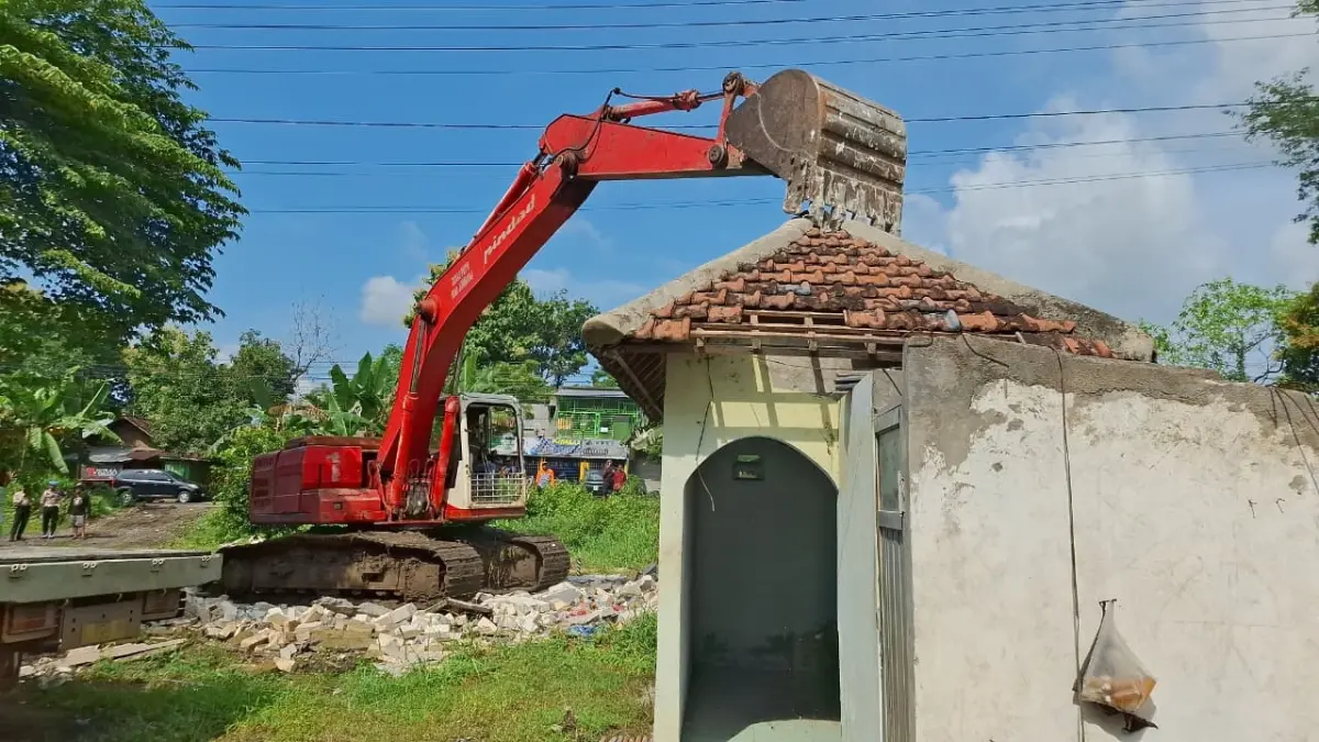 DIBONGKAR: Alat berat membongkar salah satu bangunan untuk persiapan pembangunan RTH Kabuh.