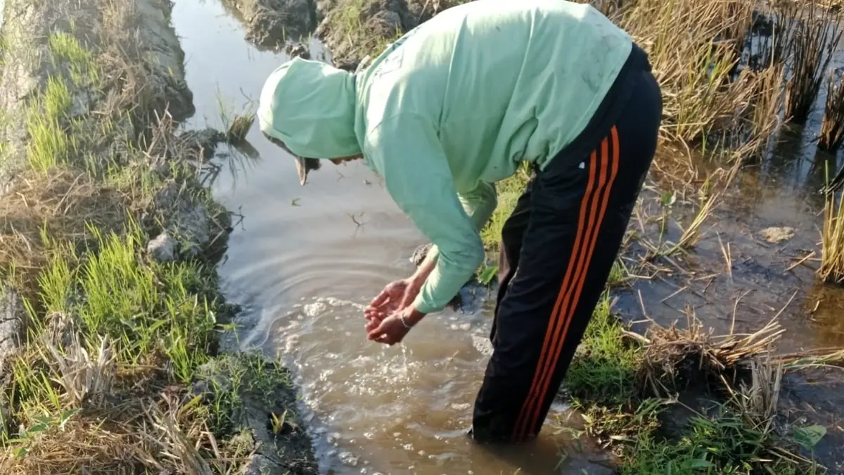 DIDUGA TERCEMAR: Petani di Desa Betek, Kecamatan Mojoagung menunjukkan kondisi air irigasi yang berbau dan berbusa.