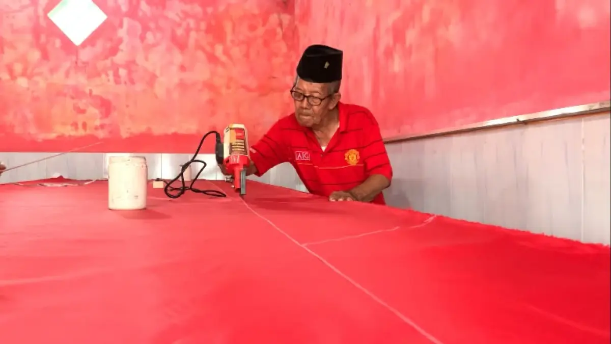 PANEN PESANAN: Mbah Alpan, warga Kelurahan Kaliwungu, Kecamatan Jombang menyelesaikan bendera pesanan pelanggannya.