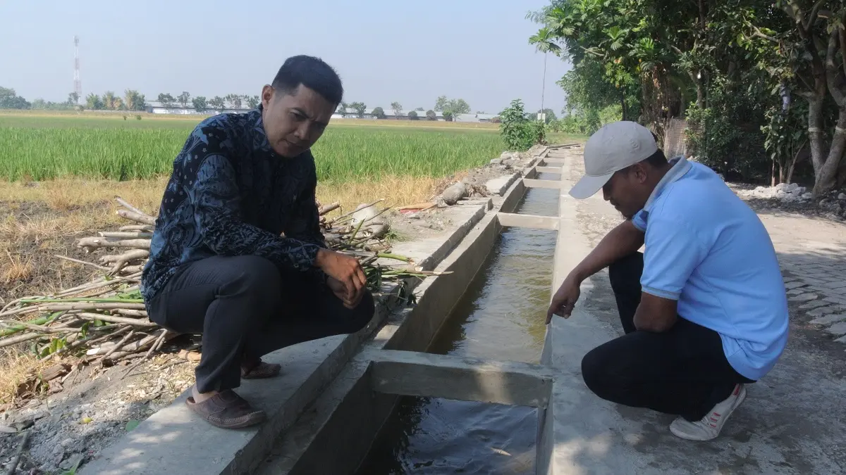 LANCAR: Sekdes Sumberagung, Kecamatan Peterongan, Haris Andi Lesmono (kiri) dan Dwi Handoko, Kaur Perencanaan Sumberagung, menunjukkan bangunan jaringan irigasi di Dusun Banjaranyar.