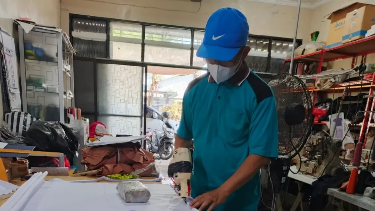 TELITI: Penjahit desa Plosogeneng Kecamatan Jombang sedang melakukan pemotongan kain seragam siswa