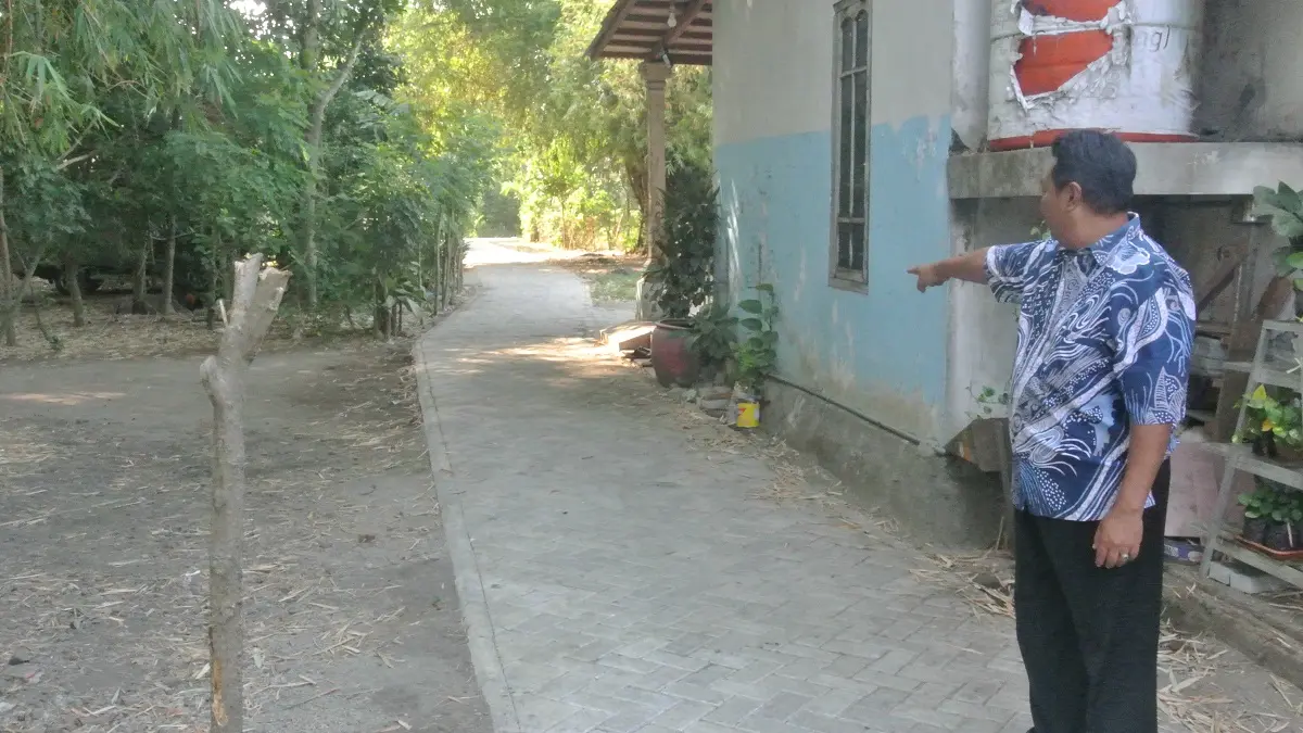 BANGUN JALAN PAVING: Sekretaris Desa Keplaksari Hariyono menunjukkan lokasi jalan lingkungan yang telah dibangun menjadi jalan paving di wilayah Desa Keplaksari.