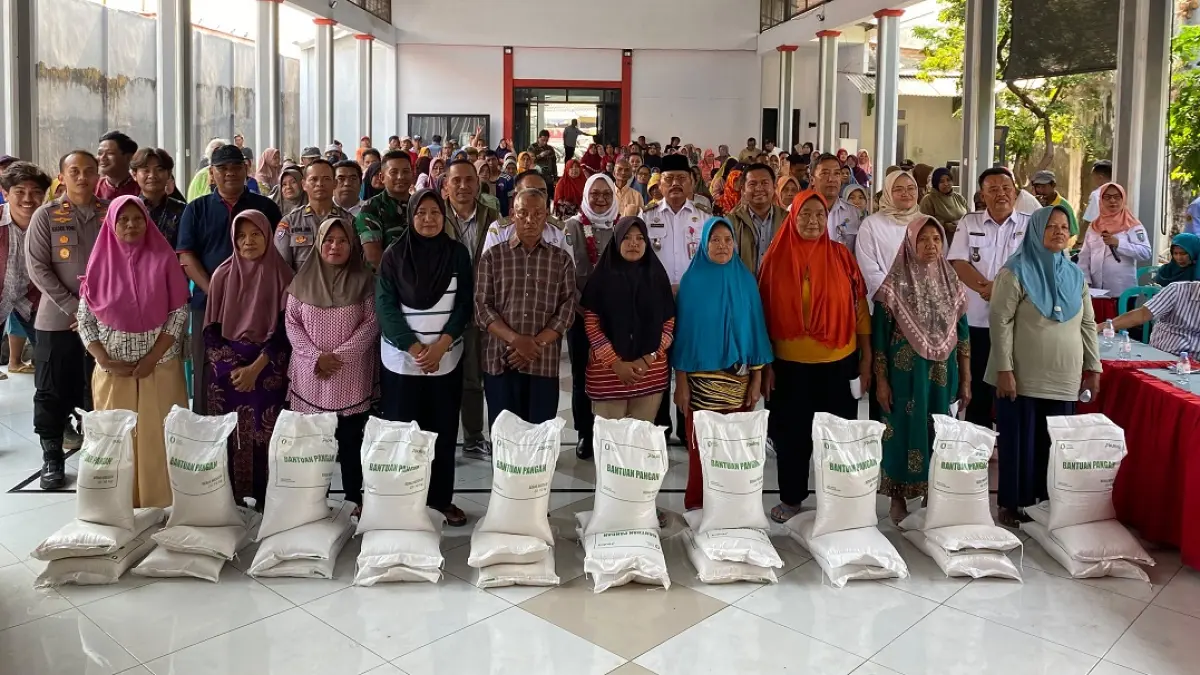 DISALURKAN: Wakil Pemimpin Wilayah Perum Bulog Kanwil Jawa Timur Sugeng Hardono mendampingi anggota Komisi IV DPR RI Hj Sadarestuwati bersama seluruh tamu dan penerima bantuan berfoto bersama di Balai Desa Bareng, Rabu (9/9). 