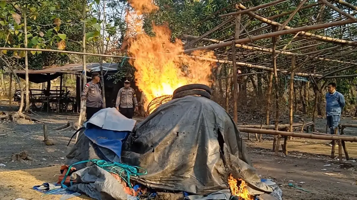 MENYALA: Arena judi sabung ayam dibakar petugas di tengah hutan jati Dusun Sendangrejo, Desa Banjardowo, Kecamatan Jombang, Selasa (15/9) sore.