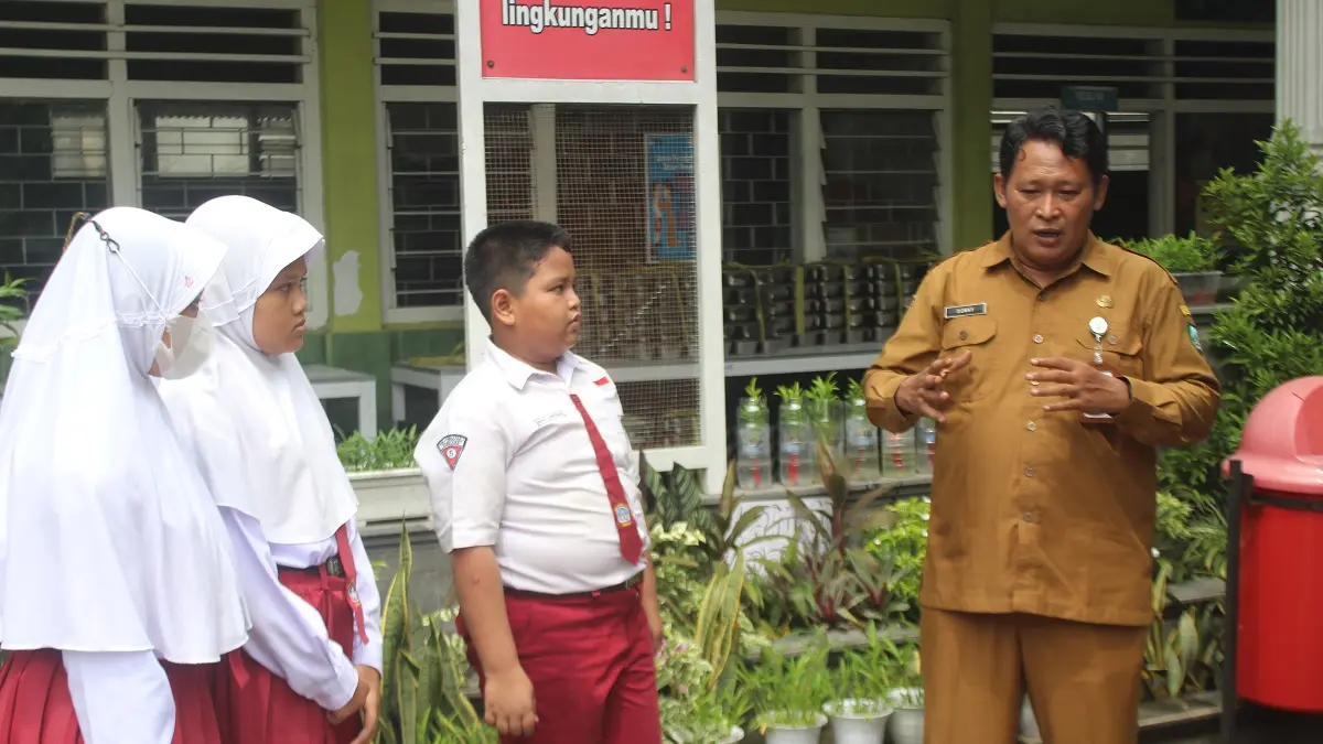 AKRAB: Donny Erfantoro, kepala SDN Jombatan 3 Kecamatan Jombang saat berinteraksi bersama siswa di halaman sekolah, (27/4).
